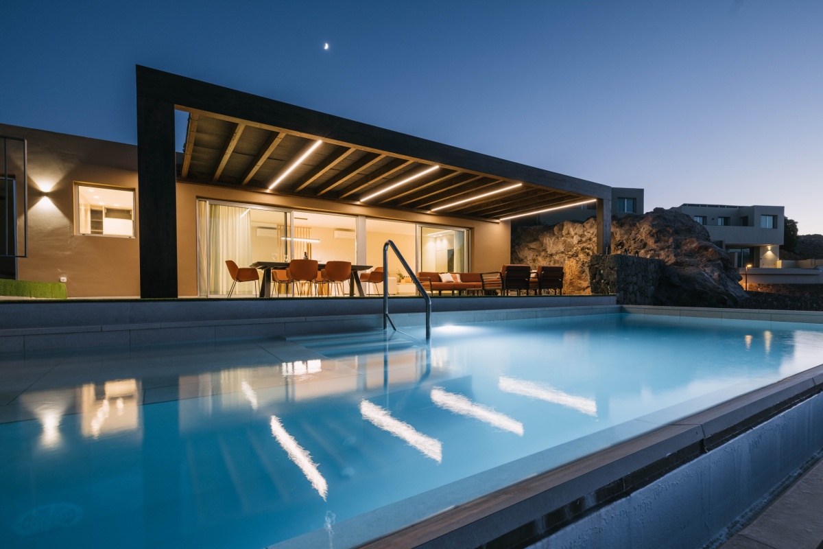 Villa moderna en Salobre Golf, Gran Canaria, con piscina iluminada al atardecer.